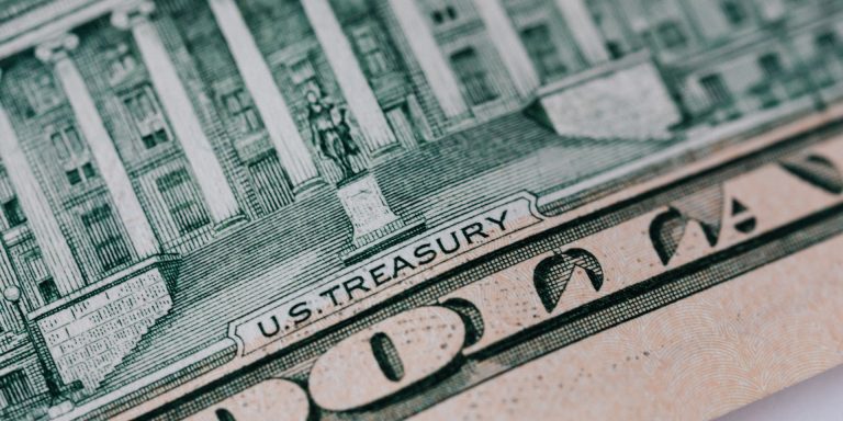 A Fraud By Any Other Name Would Be As… Expensive 7 Dollar banknote on white table, representing whistleblower amendments, insider trading, and whistleblower awards.