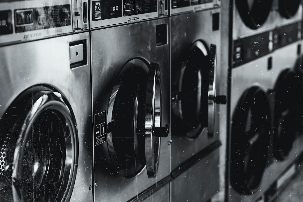 Washing machines in a laundromat, emphasizing the metallic design and operational controls, relevant to discussions on whistleblower incentives and legal compliance in various industries.