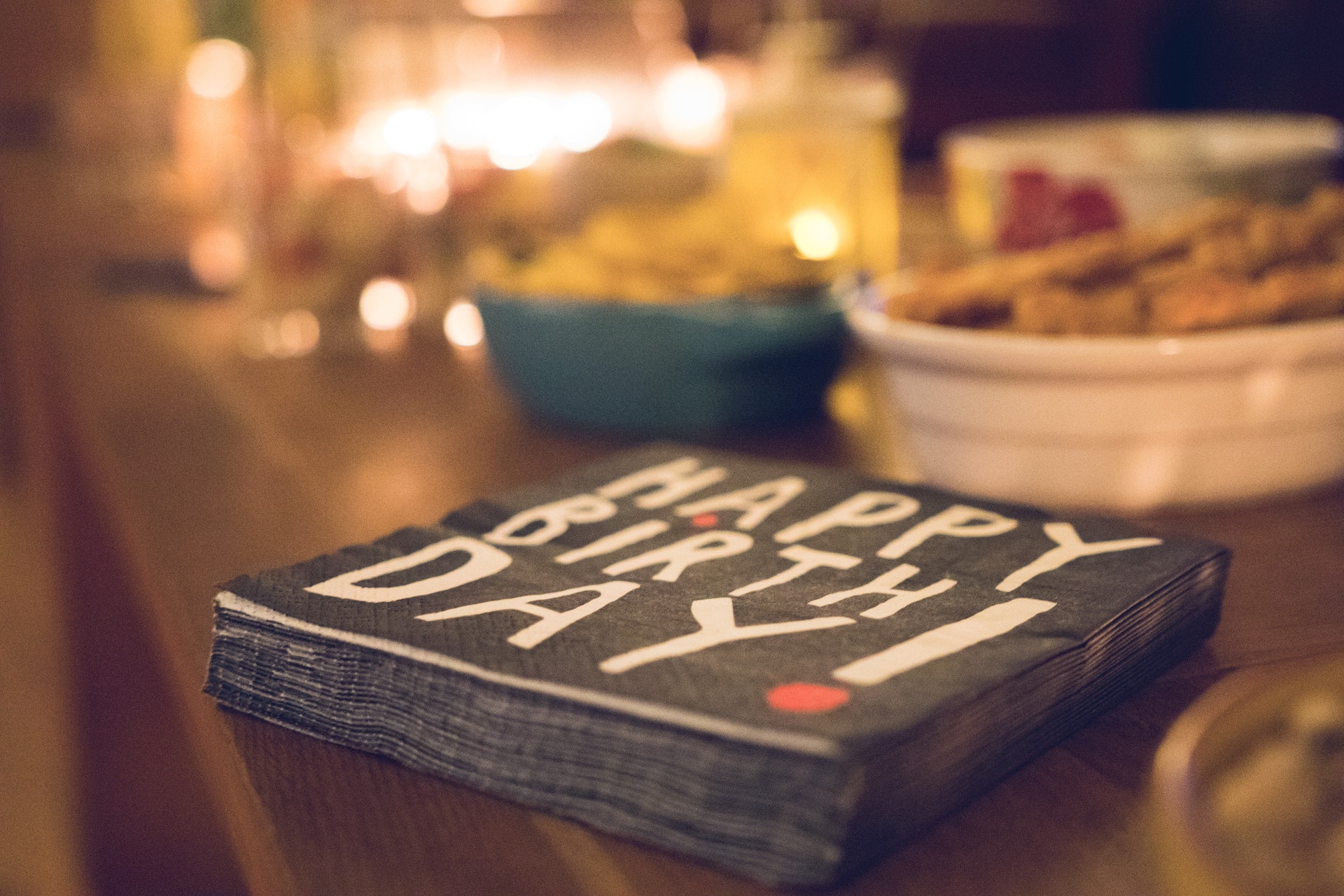 Happy Birthday napkin with festive design, celebrating the anniversary of the False Claims Act amidst a table setting with snacks and drinks.
