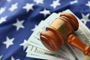 Whistleblower News 9 Gavel on top of money and a flag, representing Whistleblower Client Rewarded