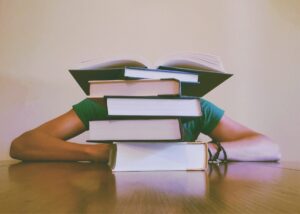 Whistleblower News 8 Student Behind Stack of Books
