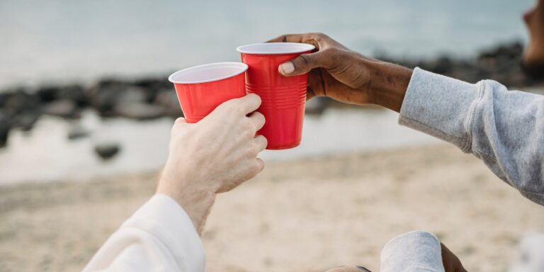False Marking Suit Against Solo Cup Lid Maker is a Bust 5 People Touching Red Solo Cups Together on a Beach