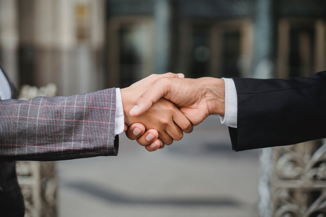 Handshake between two individuals in professional attire, symbolizing agreement and settlement related to the million Fentanyl Qui Tam case by Young Law Group, P.C.