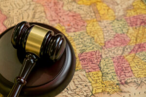 Whistleblower News 4 Judge's wooden gavel and USA map. concept of the judicial system in many States, attorney's fees in different States, justice in the American