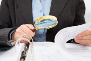 Whistleblower News 20 Close-up Of Businessperson Checking Bills With Magnifying Glass, representing Caremark Fraud