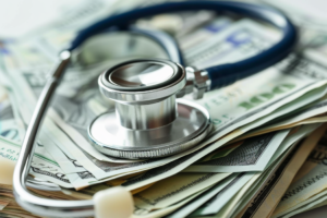 Whistleblower News 24 a stethoscope on top of money, representing Healthcare Whistleblower Attorney Helps Secure $1.2 Million from Dr. Modh and PPM