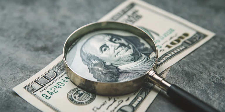 PPP Loan Fraud and Its Connection to Whistleblowers 14 A 100 dollar bill under a magnifying glass, representing PPP Loan Fraud